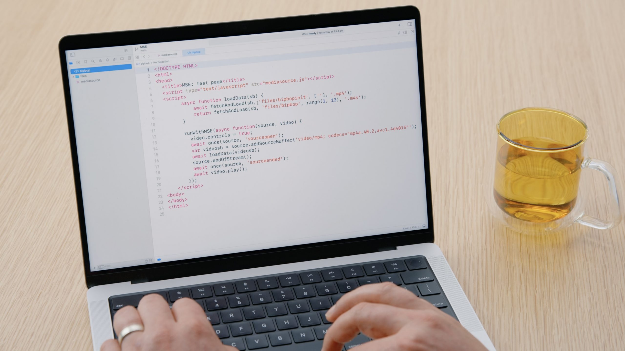 Photo of hands on a laptop with code using Managed Media Source on the screen. A still from the WWDC session. 